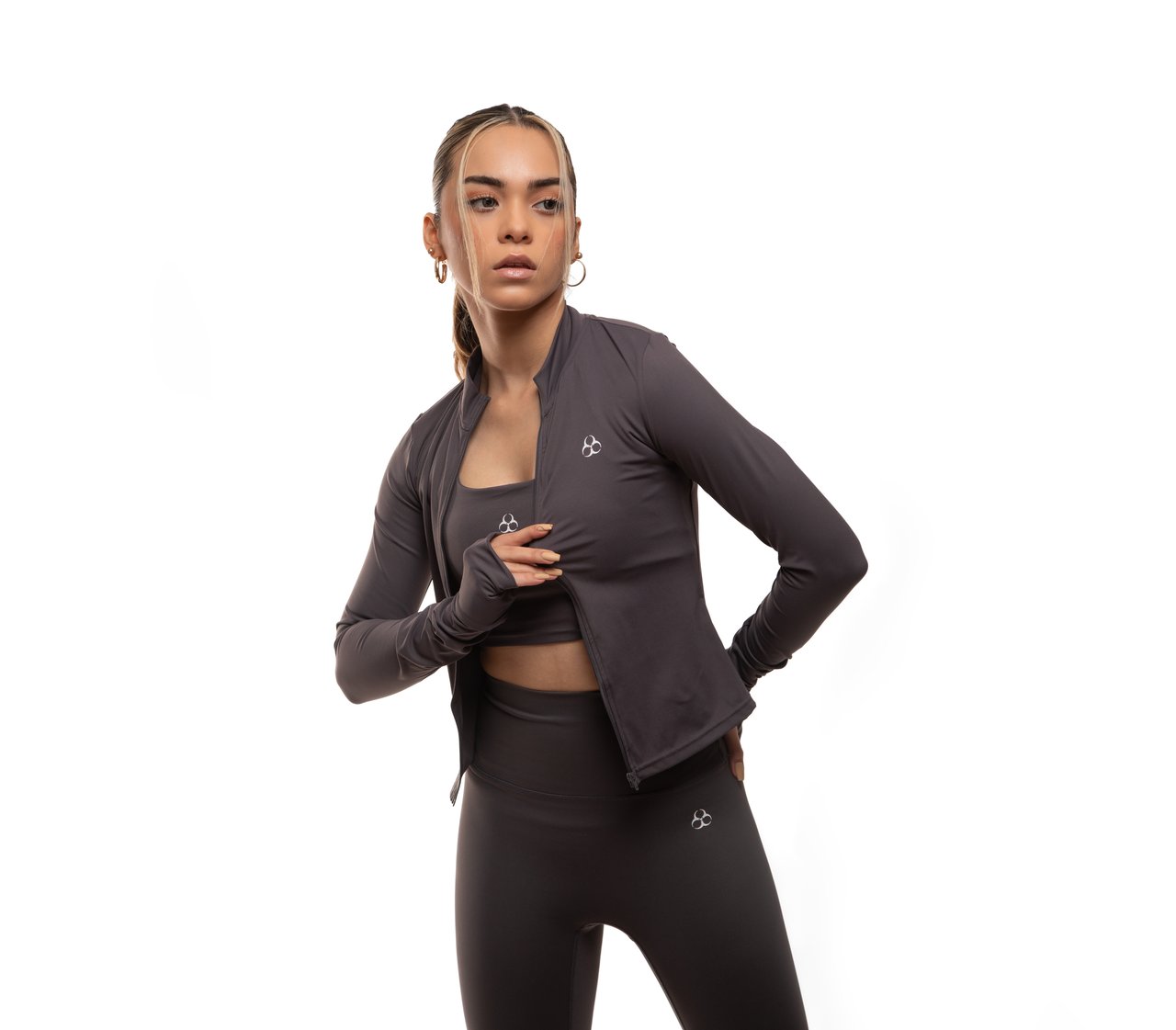 Services-02 Woman wearing stylish sportswear with a jacket and leggings in studio setting.